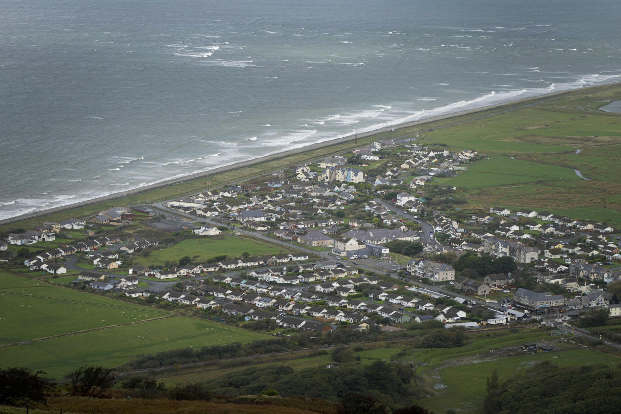 An aerial view of Fairbourne village in Gwynedd in Wales, Wednesday, Oct. 20, 2021. In north Wales, residents in the small coastal village of Fairbourne face being the U.K.'s first "climate refugees." Authorities say that by 2054, it would no longer be sustainable to keep up flood defenses there because of faster sea level rises and more frequent and extreme storms caused by climate change. (AP Photo/Kirsty Wigglesworth)