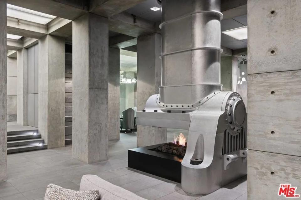 A gas hearth covered with a large metal hood in James Jannard's listed Beverly Hills mansion.