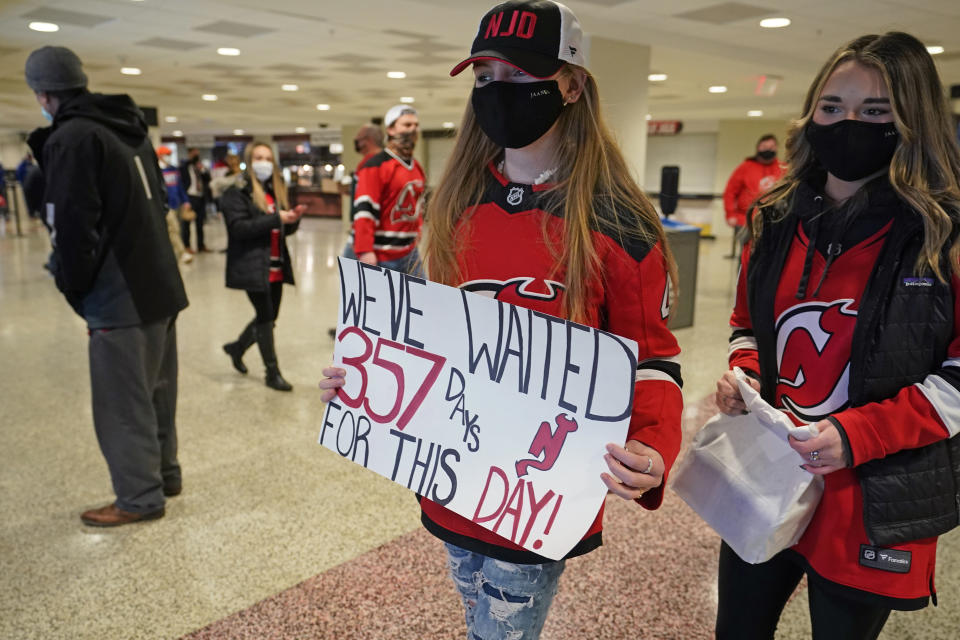 New Jersey Devils fans wait their turn to walk down to their seats for an NHL hockey game between the New Jersey Devils and the New York Islanders, Tuesday, March 2, 2021, in Newark, N.J. It was the first time fans were allowed in the Prudential Center under New Jersey's new COVID rules. (AP Photo/Kathy Willens)