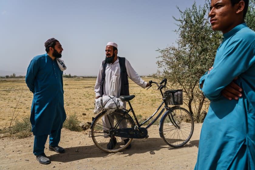 PULI ALAM, AFGHANISTAN -- SEPTEMBER 11, 2021: Nasratullah Raihan, 24, talks to passerby out in the open road near the village of Kulangar, near Puli Alam, Afghanistan, Saturday, Sept. 11, 2021. OFor the 20 years that America was here, it was problems,O he said, to the nods of others. OPlanes, missiles, rockets N all of it was here. Every day you had people killed.O (MARCUS YAM / LOS ANGELES TIMES)