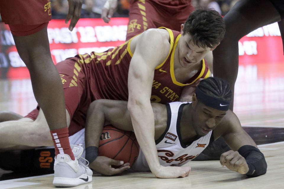 Iowa State forward Michael Jacobson, top, and Oklahoma State forward Cameron McGriff, bottom, hit the floor after the ball during the first half of an NCAA college basketball game in the first round of the Big 12 men's basketball tournament in Kansas City, Kan., Wednesday, March 11, 2020. (AP Photo/Orlin Wagner)