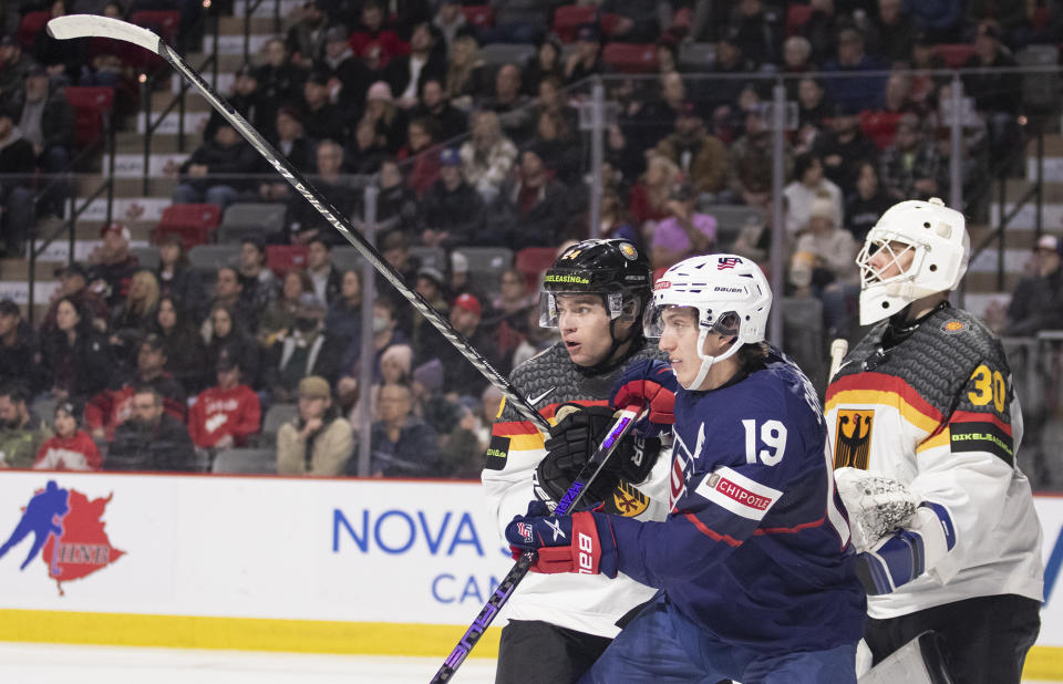 United States' Eric Hordler (19) gets caught between Germany's Roman Kechiter, left, and goaltender Nikita Quapp, right, during second-period IIHF world junior hockey championships quarterfinal match action in Moncton, New Brunswick, Monday, Jan. 2, 2023. (Ron Ward/The Canadian Press via AP)
