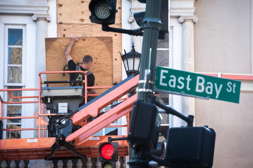 In Charleston, S.C., a city worker secures plywood boards over the windows of the Old Exchange and Provost Dungeon building on Sept. 3 in preparation for Hurricane Dorian.