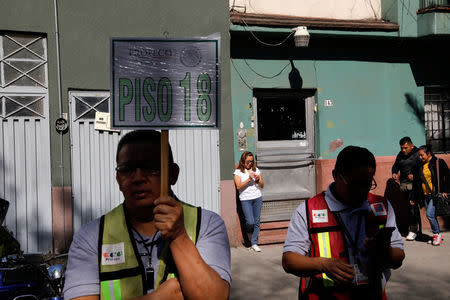 Office workers are seen at a street following an earthquake in Mexico City, Mexico February 1, 2019. REUTERS/Carlos Jasso