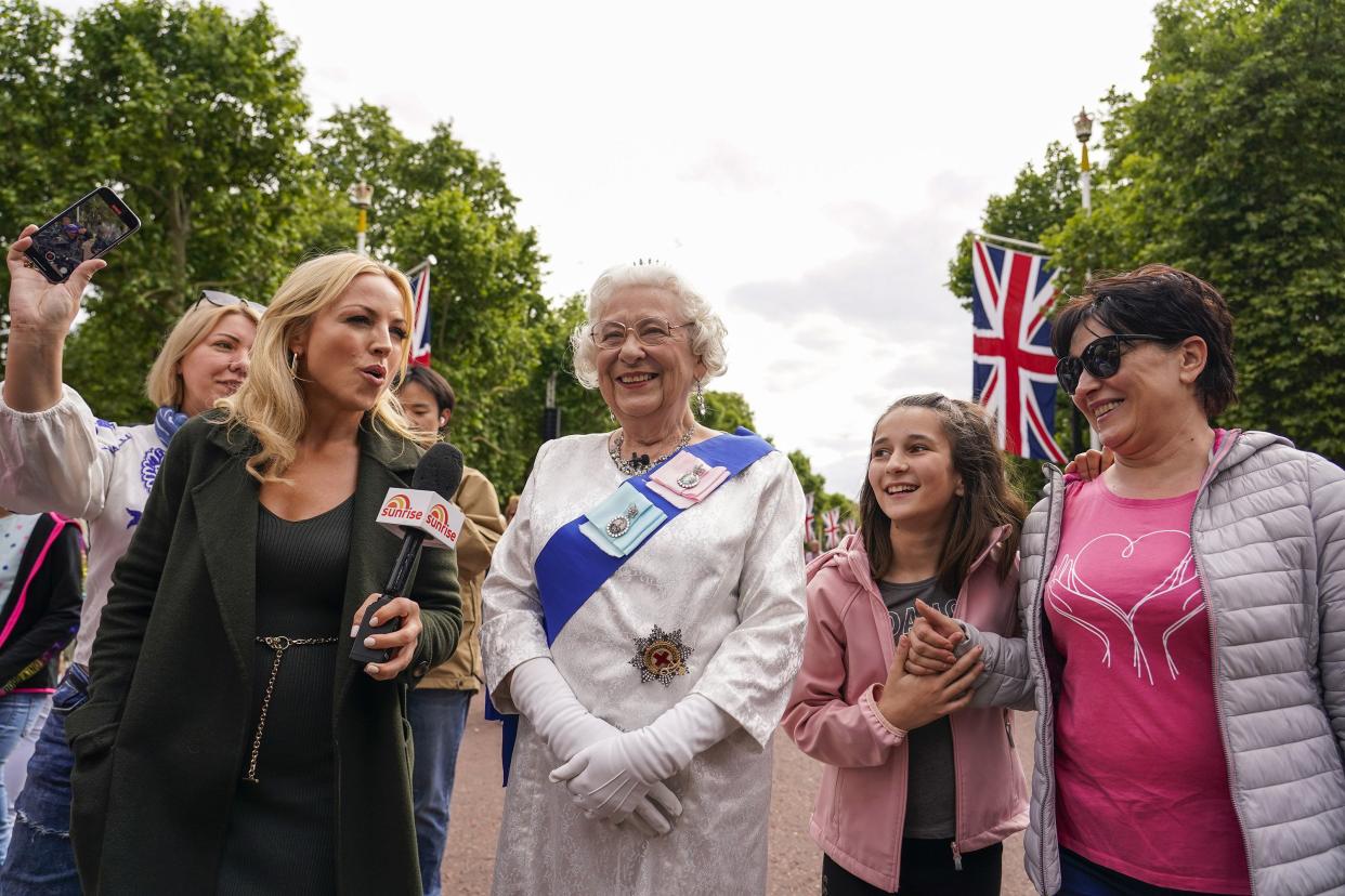 A Queen Elizabeth II impersonator is interviewed as she walks along The Mall in London on Wednesday, June 1, 2022, ahead of the start of the Queen's Jubilee weekend.