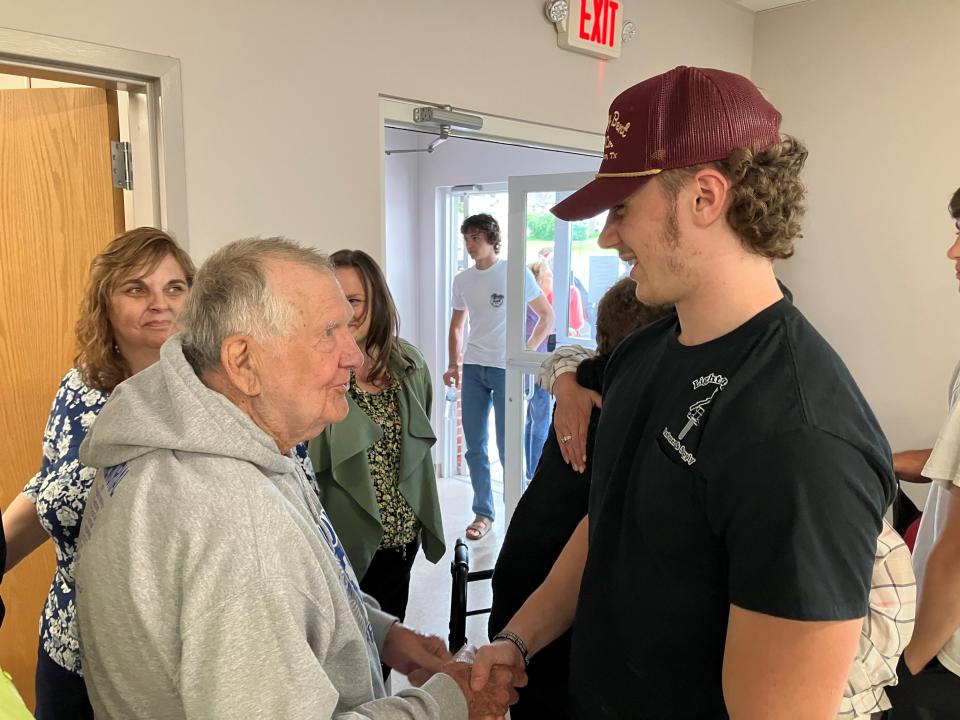 Tom Moyer, left, shakes hands with Bryer Miller, who helped save him from a house fire on March 15.