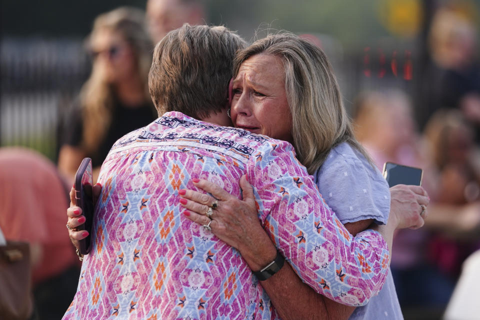 Gaylan Blizzard, right hugs a woman during a vigil for the victims of Saturday's mass shooting on Monday, July 17, 2023, in Hampton, Ga. (AP Photo/John Bazemore)