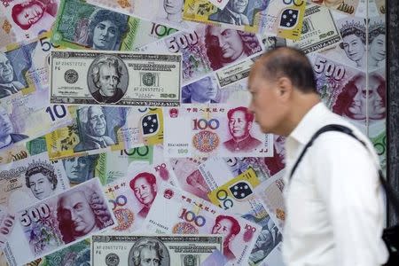 A man walks past an advertisement promoting China's renminbi (RMB) or yuan, U.S. dollar and Euro exchange services at foreign exchange store in Hong Kong, China, August 13, 2015. REUTERS/Tyrone Siu