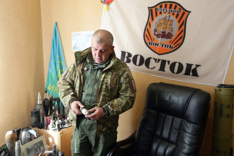 A pro-Russian rebel shows unexploded munitions on his base in Donetsk