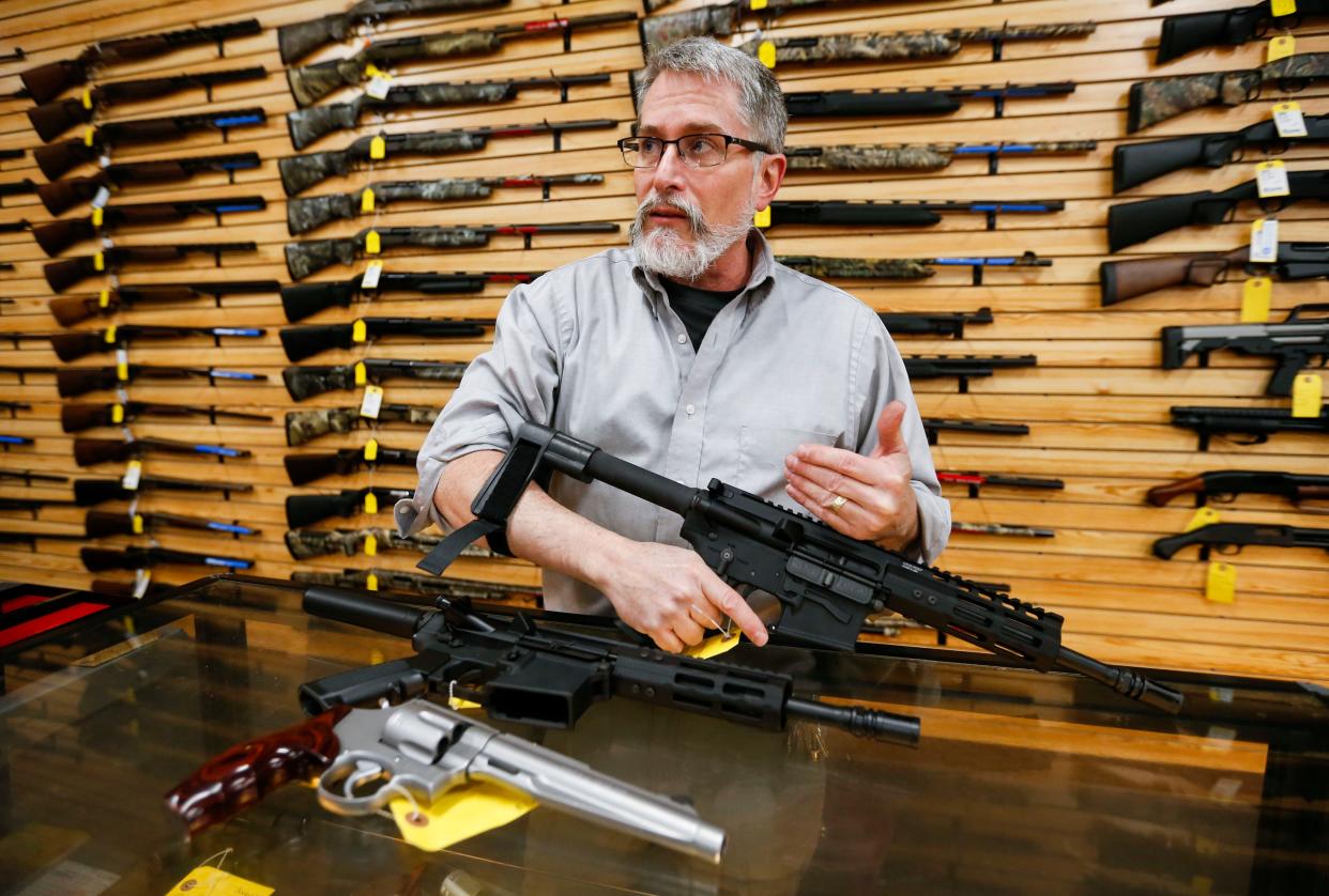 Rick Newman, owner of Cherokee Firearms in Springfield, Mo., shows how an AR-15 pistol with a pistol brace is used.