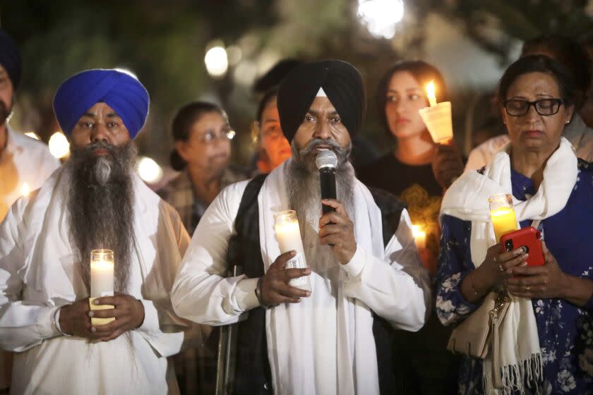 Babaji Karamjit Singh, center, a Sikh priest from the Peach Ave Gurudwara, leads prayers during candlelight vigil for a Singh family at Bob Hart Square in Merced, Calif., on Thursday, Oct. 6, 2022. Four members of the Singh family were abducted and killed this week. The suspect in the kidnapping and killings of an 8-month-old baby, her parents and an uncle had worked for the family's trucking business and had a longstanding feud with them that culminated in an act of "pure evil," a sheriff said Thursday. (Salgu Wissmath/San Francisco Chronicle via AP)