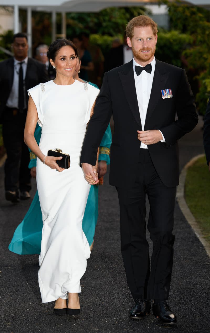 <p> Meghan and Prince Harry attended an evening reception and dinner with the King of Tonga. For the occasion, Prince Harry wore a black suit while Meghan wore a custom white ivory crepe column gown by Theia. She accessorized with Aquazzura pumps, Birks earrings, and a Givenchy clutch. The royal also wore Princess Diana&apos;s&#xA0;aquamarine ring&#xA0;again (Meghan first wore it to her wedding reception back in May). </p>
