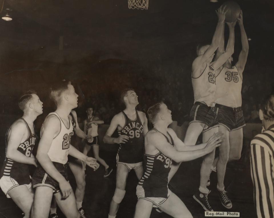 Harley Pearson (23) and Bob Heflin (35) battle each other for a rebound against Princeville, while Jim Asplund (25) looks on.