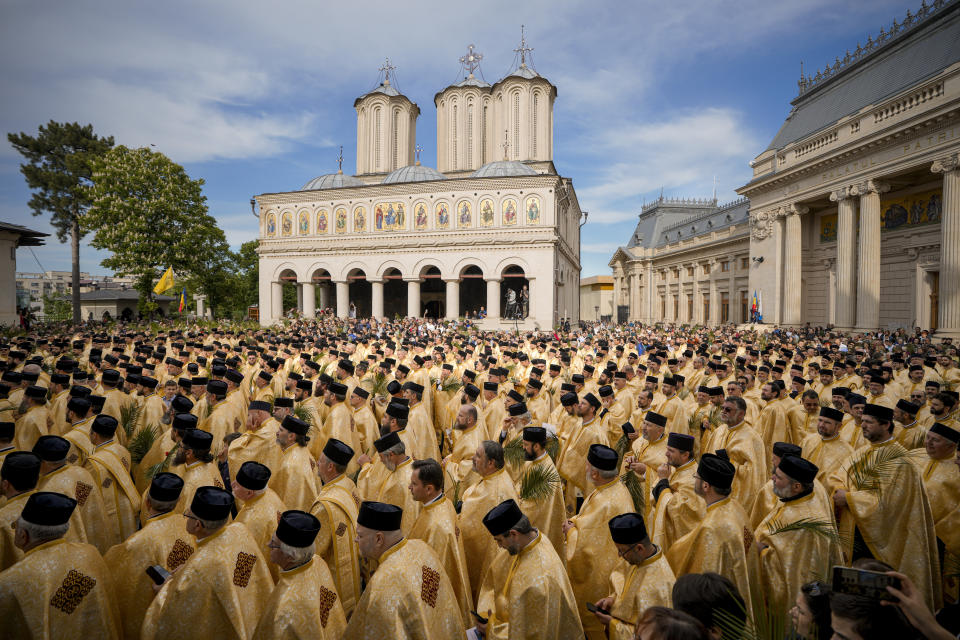 Romanian Orthodox priests and believers stand outside the Patriarchal Cathedral after an Orthodox Palm Sunday pilgrimage in Bucharest, Romania, April 27, 2024. (AP Photo/Vadim Ghirda)