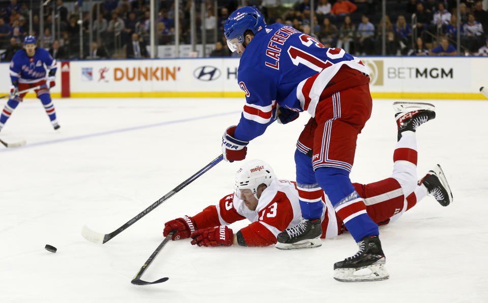 New York Rangers left wing Alexis Lafreniere, top, and Detroit Red Wings left wing Adam Erne battle for the puck during the first period of an NHL hockey game Sunday, Nov. 6, 2022, in New York. (AP Photo/John Munson)