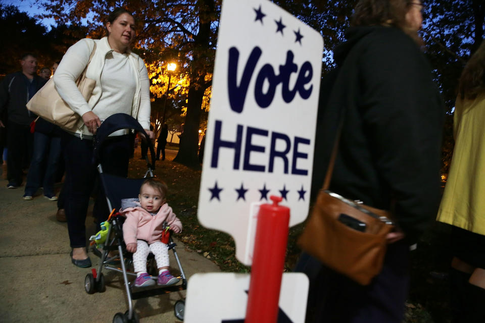 ALEXANDRIA, VA - NOVEMBER 08:  Local resident Kendra Isaacson (L) waits in-line with her 11-month-old daughter Katie Isaacson for casting her ballot outside a polling place on Election Day November 8, 2016 in Alexandria, Virginia. Americans across the nation are picking their choice for the next president of the United States.  (Photo by Alex Wong/Getty Images)