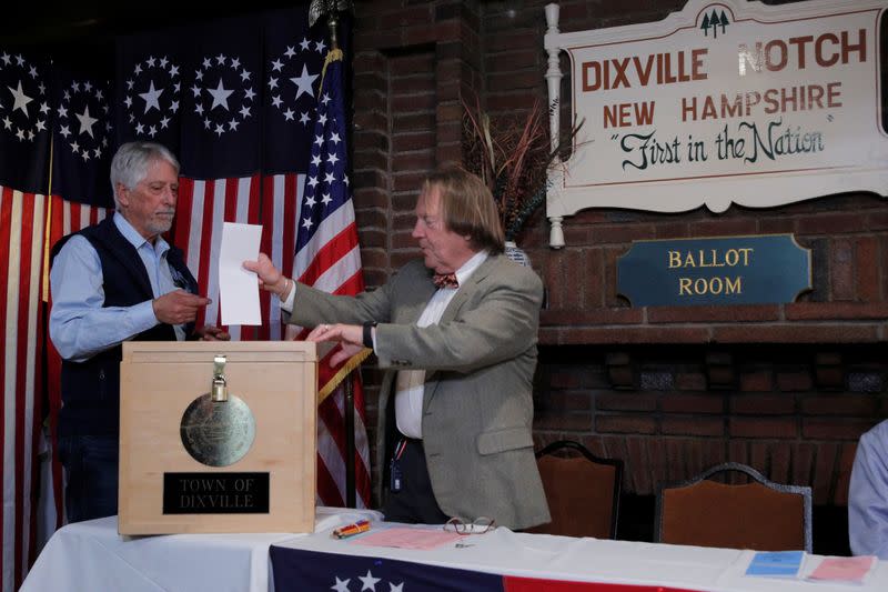 Les Otten hands his ballot to town moderator Tom Tillotson to cast the first ballot shortly after midnight in the U.S. Democratic presidential primary at the Hale House at Balsams Hotel in Dixville Notch