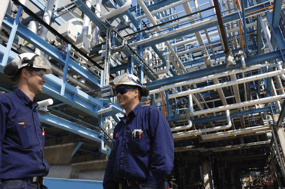 Two men talking at an energy processing plant.