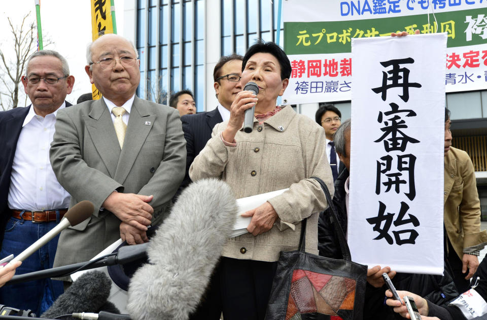 Hideko Hakamada, center, sister of Iwao Hakamada, speaks as lead lawyer Katsuhiko Nishijima, second from left, listens after the Shizuoka District Court decided to reopen a high-profile murder case in which Hakamada has been on death row for more than 30 years, in front of the court in Shizuoka, central Japan, Thursday, March 27, 2014. The court on Thursday suspended the death sentence for 78-year-old Hakamada and ordered him released after 48 years behind bars. Guinness World Records lists him the longest-serving death row inmate. The court says DNA analysis obtained by his lawyers suggests investigators fabricated evidence. The banner held by a supporter reads: "Reopening of the case." (AP Photo/Kyodo News) JAPAN OUT, MANDATORY CREDIT