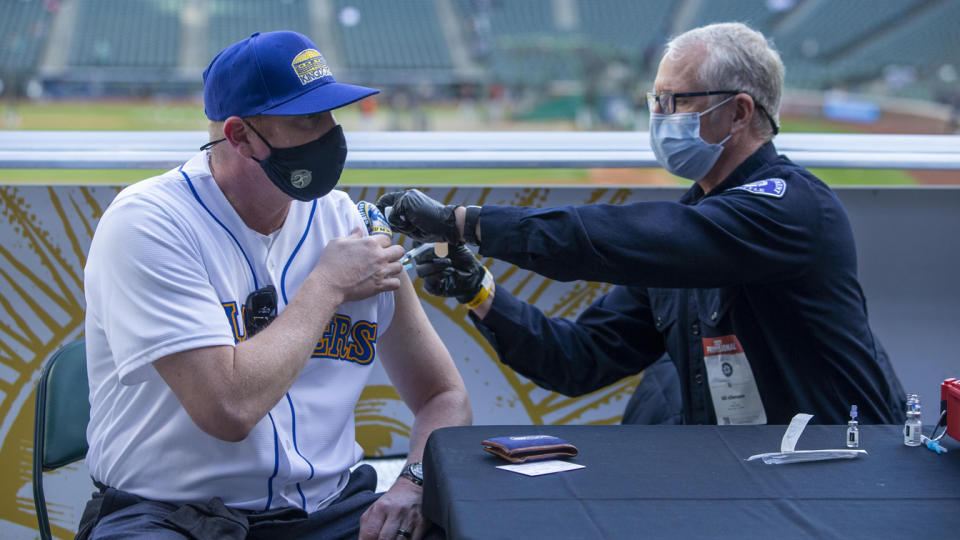 Seattle Fire Department EMT Bill Allemann gives Chris Hoffman, of Kent, Washington a Johnson & Johnson Covid-19 vaccine during batting practice before a game between the Seattle Mariners and Baltimore Orioles at T-Mobile Park. (Joe Nicholson-USA TODAY Sports via Reuters)