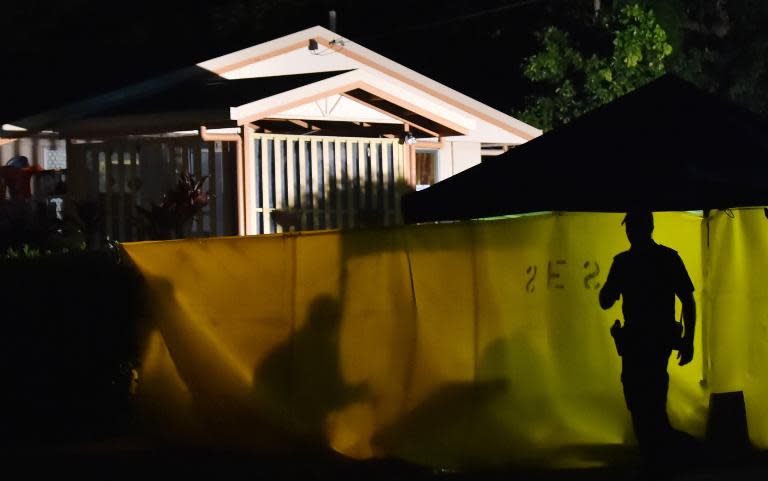 A police officer works at the scene where eight children were found dead in a house in the northern Australian city of Cairns, on December 20, 2015