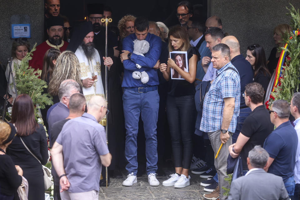 Parents of Ema Kobiljski, 13, mourn during the funeral procession at the central cemetery in Belgrade, Serbia, Saturday, May 6, 2023. Her schoolmate, a 13-year-old boy, on Wednesday, used his father's guns to kill eight fellow students and a guard. (AP Photo/Armin Durgut)