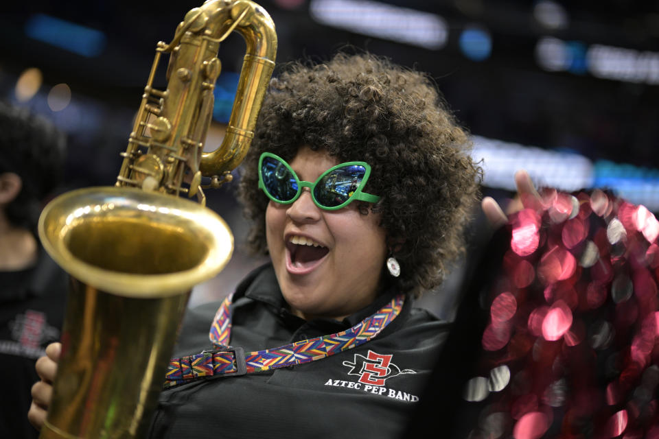 A member of the San Diego State pep band cheers while performing before a second-round college basketball game against Furman in the NCAA Tournament, Saturday, March 18, 2023, in Orlando, Fla. (AP Photo/Phelan M. Ebenhack)