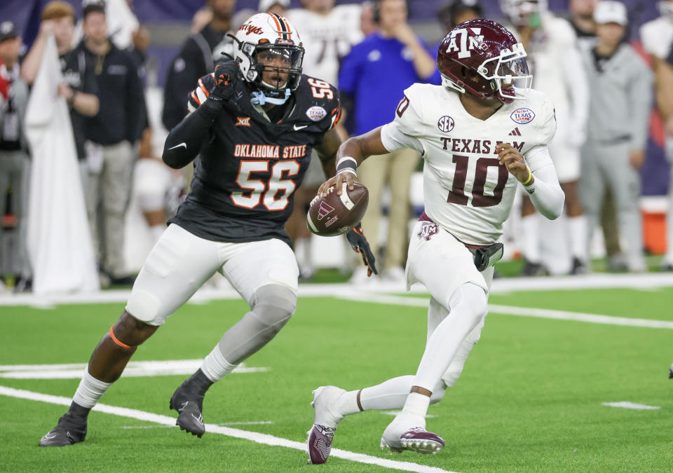 Dec 27, 2023; Houston, TX, USA; Texas A&M Aggies quarterback Marcel Reed (10) scrambles from Oklahoma State Cowboys defensive end Xavier Ross (56) in the second half at NRG Stadium. Mandatory Credit: Thomas Shea-USA TODAY Sports