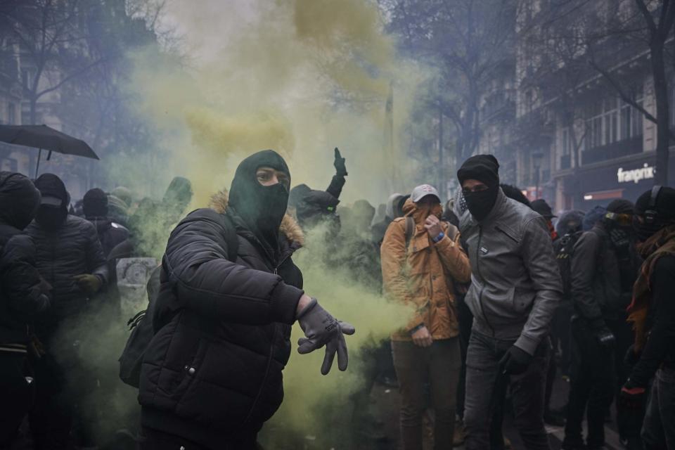 A protestor throws a rock towards French Riot Police during a rally in Paris: Getty Images