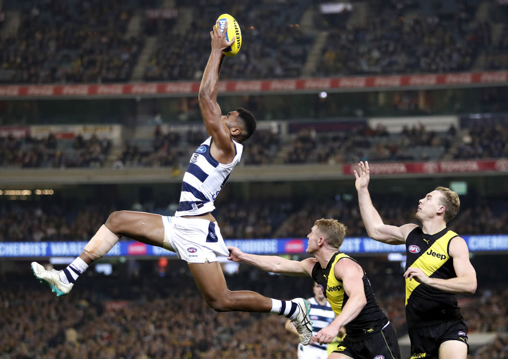 Esava Ratugolea of the Cats marks the ball ahead of Josh Caddy of the Tigers and Tom Lynch of the Tigers during the 2019 AFL round 12 match between the Richmond Tigers and the Geelong Cats at the Melbourne Cricket Ground.