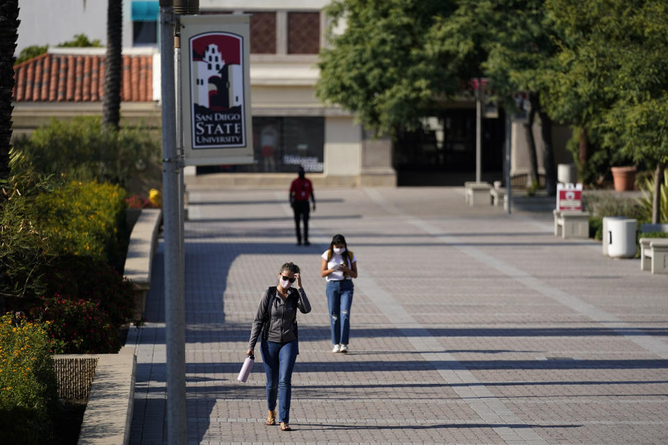 FILE - In this Sept. 2, 2020, file photo, people walk on campus at San Diego State University in San Diego. Officials in college towns all over the U.S. are fretting that off-campus students are being counted in places other than the communities where their schools are located. (AP Photo/Gregory Bull, File)