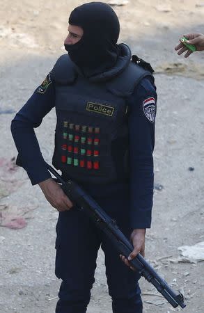 A member of police special forces holds a shotgun as he takes up position during an Islamist protest in El-Talbyia, near Giza, south of Cairo, November 28, 2014. REUTERS/Amr Abdallah Dalsh