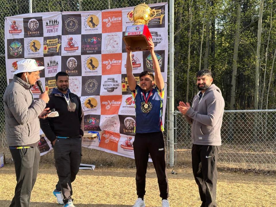 Raman Kumar, captain of the Whitehorse Strikers, hoists the winning trophy in Whitehorse on May 19. 