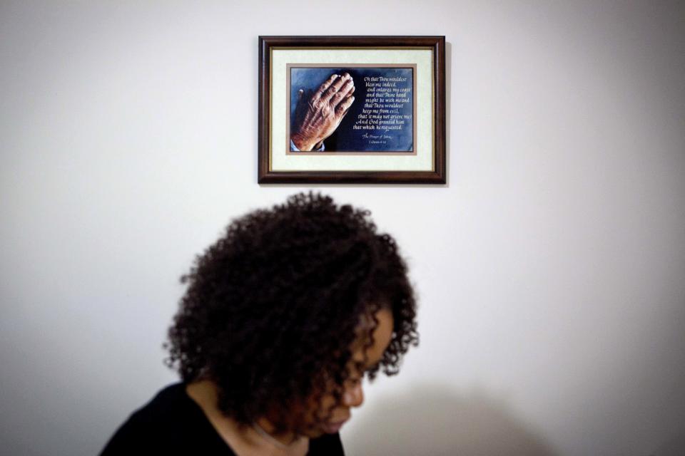 A prayer in a frame hangs on the wall as Patricia Jackson sifts through bank documents in her home Saturday, June 16, 2012, in Marietta, Ga. On a suburban cul-de-sac northwest of Atlanta, the Jacksons are struggling to keep a house worth $100,000 less than they owe. Their voices and those of many others tell the story of a country that, for all the economic turmoil of the past few years, continues to believe things will get better. But until it does, families are trying to hang on to what they've got left. The Great Recession claimed nearly 40 percent of Americans' wealth, the Federal Reserve reported last week. The new figures, showing Americans' net worth has plunged back to what it was in 1992, left economists shuddering. (AP Photo/David Goldman)
