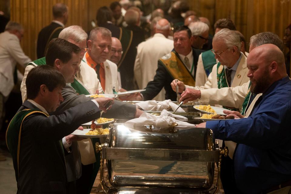 Members of the Savannah St. Patrick's Day Parade Committee eat breakfast (which included green grits) at the Mansion on Forsyth early St. Patrick's Day morning.