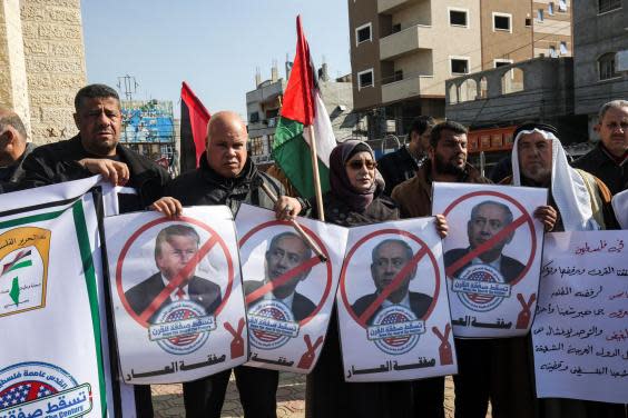 Palestinian demonstrators chant slogans while holding portraits of US President Donald Trump and Israeli Prime Minister Benjamin Netanyahu, during a protest against Trump's expected announcement of a peace plan, in Gaza (Photo by SAID KHATIB/AFP via Getty Images)