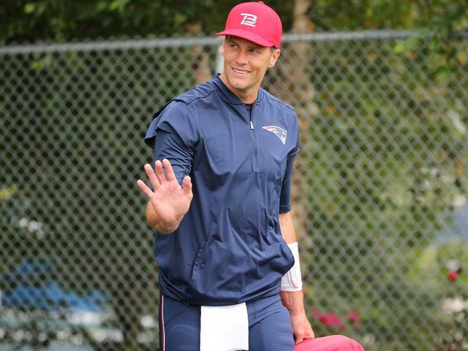 Tom Brady waves as he walks into Patriots training camp in 2017.