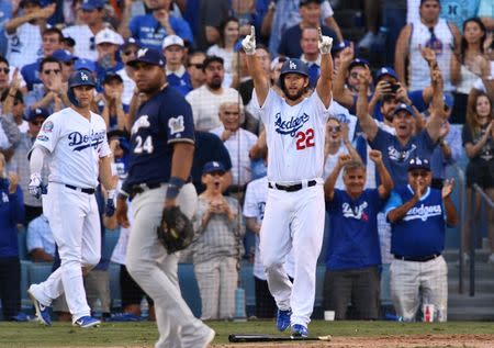 Oct 17, 2018; Los Angeles, CA, USA; Los Angeles Dodgers starting pitcher Clayton Kershaw (22) celebrates after scoring on a single by third baseman Justin Turner (10) in the seventh inning against the Milwaukee Brewers in game five of the 2018 NLCS playoff baseball series at Dodger Stadium. Mandatory Credit: Robert Hanashiro-USA TODAY Sports