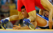 Soner Sucu of Turkey (red) competes with Roberto Monzon of Cuba in their Men's Greco-Roman 60 kg repechage round 2 round wrestling event during Day 4 of the Beijing 2008 Olympic Games at the China Agriculture University Gymnasiumon August 12, 2008 in Beijing, China. (Stu Forster/Getty Images)