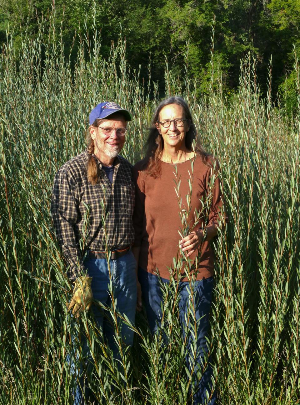 Folk artists Lindsay Lee (left) and Lee Zieke stand amid willow plants on their property outside of Decorah, in northeast Iowa. They cultivate willow to use in handcrafting baskets and other artful pieces, even small boats.