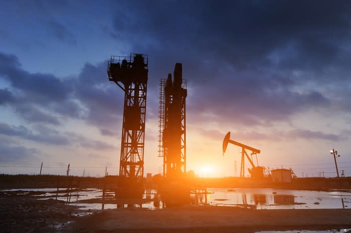 An oil pump with a bright sunset in the background