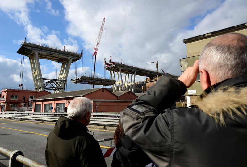 FILE PHOTO: People look at the collapsed Morandi Bridge in Genoa