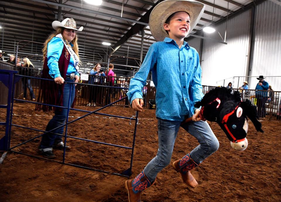 Hank Coles leaps from the chute as he competes in the “rough stock” category for 7-9 year-olds during Saturday’s Stick Horse Rodeo at the Western Heritage Classic.