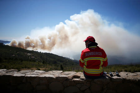A firefighter watchs a forest fire next to the village of Monchique, Portugal August 8, 2018. REUTERS/Pedro Nunes