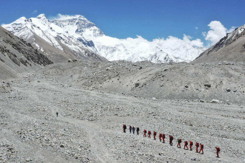 FILE - In this May 16, 2020, file photo released by Xinhua News Agency, Chinese surveyors hike toward a higher spot from the base camp on Mount Qomolangma at an altitude of 5,200 meters. China has opened the spring Everest claiming season from the northern approach amid strict measures to prevent the spread of COVID-19. A total of 38 people have been issued permits to climb the world’s highest peak, known as Qomolongma in Tibetan, between March 31 and May 20, state media reported Friday, May 7, 2021. (Jigme Dorje/Xinhua via AP, File)