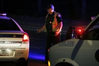 A Phoenix Police officer secures a perimeter near the scene of a shooting in Phoenix, Ariz., Sunday, March 29, 2020. At least three Phoenix police officers were shot Sunday night on the city's north side, authorities said. (AP Photo/Ross Franklin)