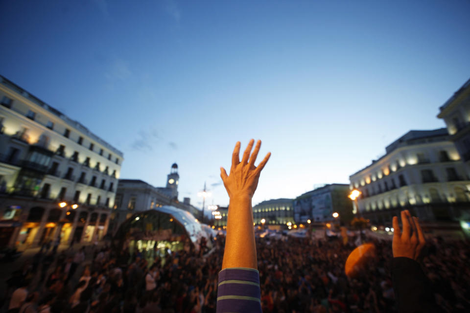 Demonstrators raise their hands as they listen to a speaker at Madrid's landmark Puerta del Sol May 31, 2011. Tens of thousands of protesters have joined those camped out for the past seventeen days at Madrid's Puerta del Sol, to protest against the government's handling of an economic crisis which broke out in 2008. REUTERS/Susana Vera (SPAIN - Tags: CIVIL UNREST POLITICS BUSINESS)