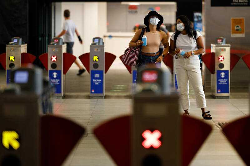 Commuters are seen wearing masks at a train station in Sydney.