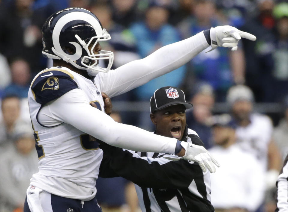 <p>Field judge Dale Shaw, right, tries to separate Los Angeles Rams outside linebacker Robert Quinn, left, from a scuffle with Seattle Seahawks offensive tackle Duane Brown in the second half of an NFL football game, Sunday, Dec. 17, 2017, in Seattle. (AP Photo/Elaine Thompson) </p>