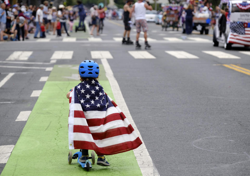 Two and a half year old Zacky Kaplan rides his scooter while draped in the American flag as he makes his way along the parade route during the Santa Monica Fourth of July Parade on July 4, 2019 in Santa Monica, Calif. (Photo: Richard Vogel/AP)